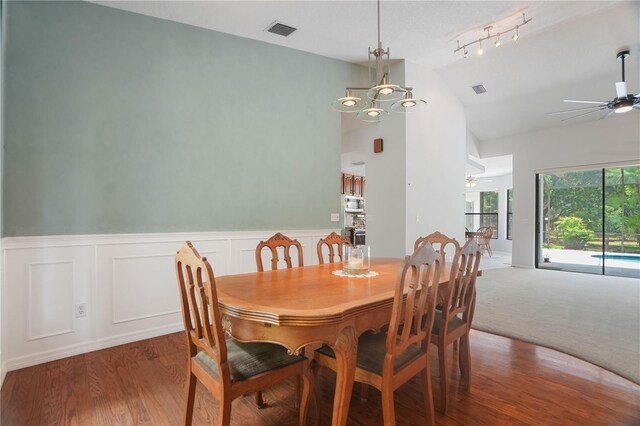8518 Quail Hollow Blvd, Wesley Chapel, FL 33544 - dining room with vaulted ceiling, a ceiling fan, a wainscoted wall, wood finished floors, and a chandelier
