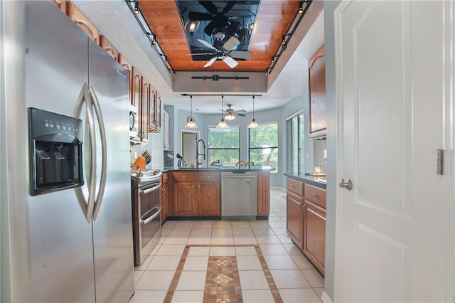 8518 Quail Hollow Blvd, Wesley Chapel, FL 33544 - kitchen with stainless steel appliances, a ceiling fan, a peninsula, brown cabinets, and a sink