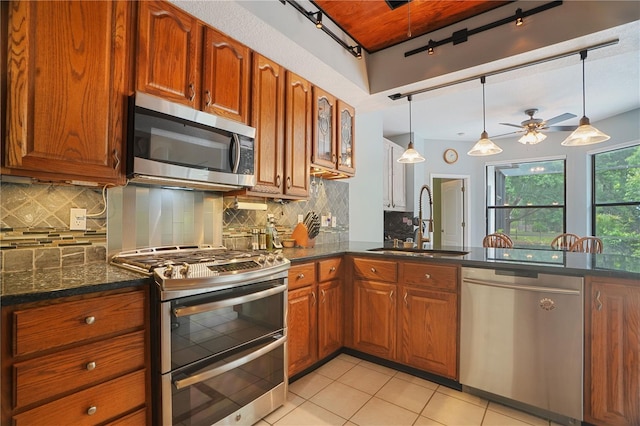 8518 Quail Hollow Blvd, Wesley Chapel, FL 33544 - kitchen with appliances with stainless steel finishes, a sink, ceiling fan, brown cabinets, and light tile patterned flooring