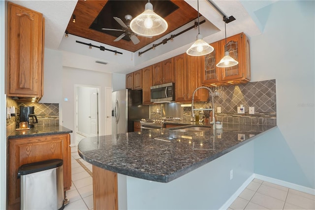 8518 Quail Hollow Blvd, Wesley Chapel, FL 33544 - kitchen with appliances with stainless steel finishes, track lighting, light tile patterned flooring, a peninsula, and dark stone counters