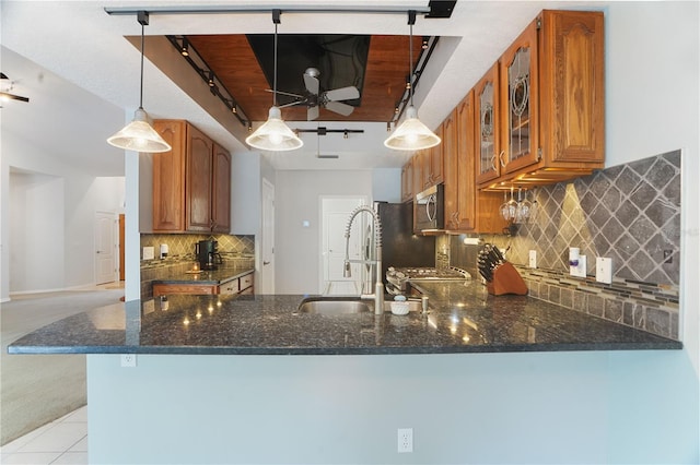 8518 Quail Hollow Blvd, Wesley Chapel, FL 33544 - kitchen featuring track lighting, a sink, brown cabinetry, a peninsula, and stainless steel microwave