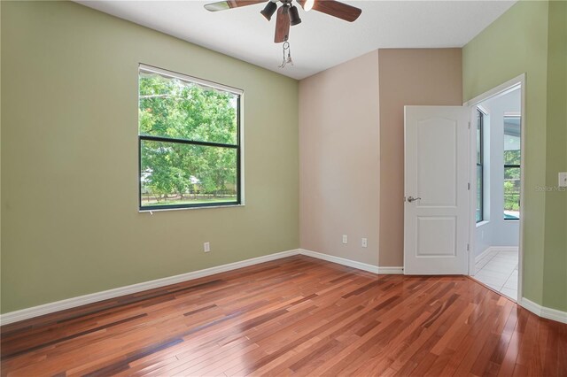 8518 Quail Hollow Blvd, Wesley Chapel, FL 33544 - unfurnished room with hardwood / wood-style floors, a ceiling fan, and baseboards