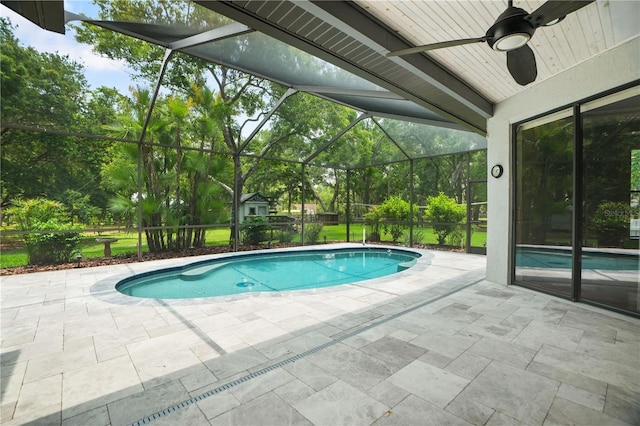 8518 Quail Hollow Blvd, Wesley Chapel, FL 33544 - outdoor pool featuring a patio area, a ceiling fan, glass enclosure, and view of scattered trees