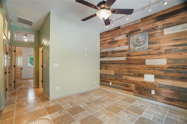 8518 Quail Hollow Blvd, Wesley Chapel, FL 33544 - spare room with stone tile flooring, wood walls, vaulted ceiling, a ceiling fan, and baseboards