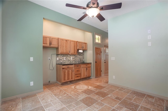 8518 Quail Hollow Blvd, Wesley Chapel, FL 33544 - kitchen with a ceiling fan, dark countertops, stone tile flooring, baseboards, and backsplash
