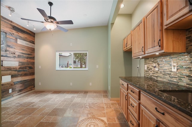8518 Quail Hollow Blvd, Wesley Chapel, FL 33544 - kitchen with wooden walls, a ceiling fan, tasteful backsplash, stone tile flooring, and dark stone counters