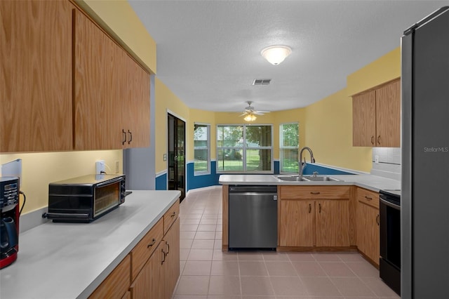 35046 Smoketree Ln, Dade City, FL 33523 - kitchen featuring appliances with stainless steel finishes, a peninsula, light countertops, ceiling fan, and light tile patterned floors
