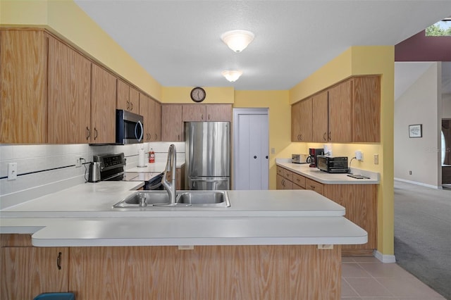 35046 Smoketree Ln, Dade City, FL 33523 - kitchen with appliances with stainless steel finishes, a peninsula, light countertops, decorative backsplash, and light tile patterned floors
