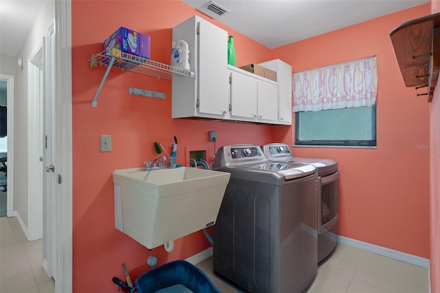 35046 Smoketree Ln, Dade City, FL 33523 - laundry area featuring cabinet space, washer and dryer, and light tile patterned floors
