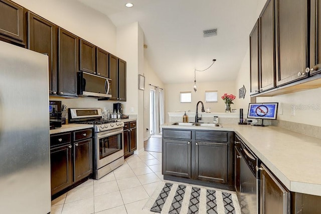 8335 Crescent Moon Dr, New Port Richey, FL 34655 - kitchen with appliances with stainless steel finishes, a sink, lofted ceiling, a peninsula, and light countertops