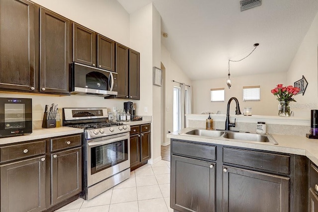 8335 Crescent Moon Dr, New Port Richey, FL 34655 - kitchen featuring stainless steel appliances, a sink, dark brown cabinetry, light countertops, and light tile patterned flooring