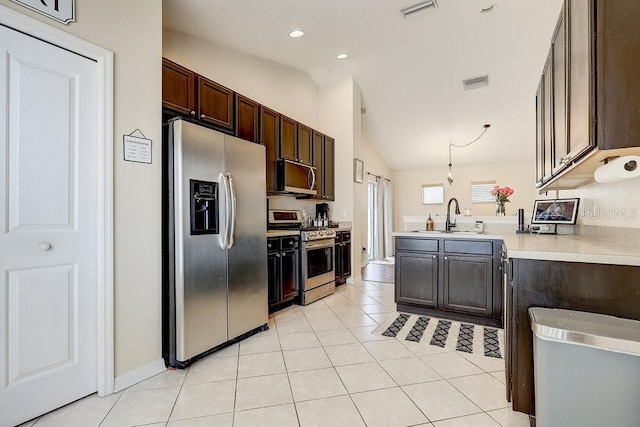 8335 Crescent Moon Dr, New Port Richey, FL 34655 - kitchen with appliances with stainless steel finishes, a sink, vaulted ceiling, light countertops, and a peninsula