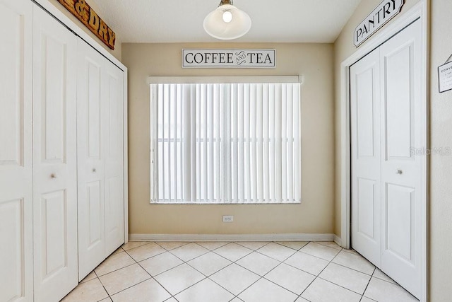 8335 Crescent Moon Dr, New Port Richey, FL 34655 - unfurnished bedroom featuring a closet, light tile patterned flooring, and baseboards