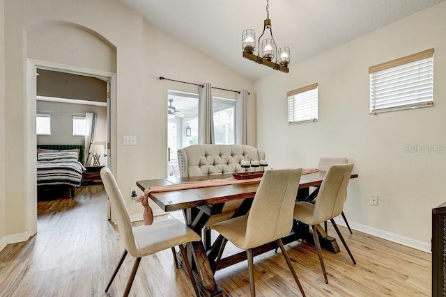 8335 Crescent Moon Dr, New Port Richey, FL 34655 - dining room with light wood-style floors, vaulted ceiling, baseboards, and a chandelier