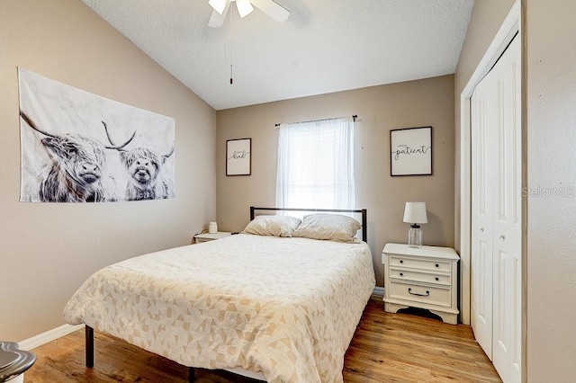 8335 Crescent Moon Dr, New Port Richey, FL 34655 - bedroom featuring a closet, wood finished floors, vaulted ceiling, ceiling fan, and baseboards