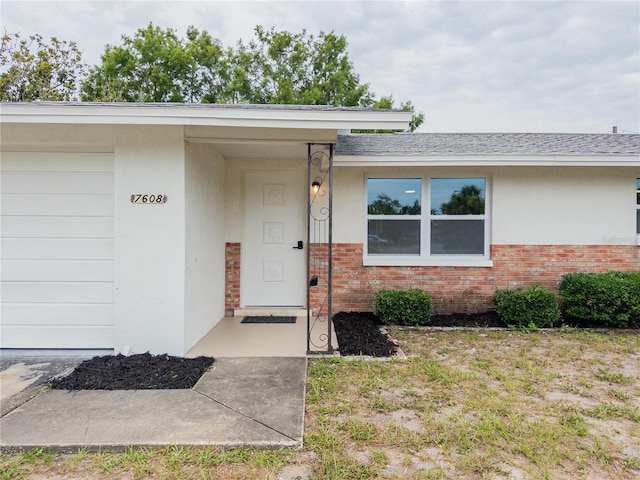 7608 Bougenville Dr, Port Richey, FL 34668 - property entrance featuring brick siding and a shingled roof