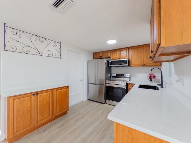 7608 Bougenville Dr, Port Richey, FL 34668 - kitchen featuring appliances with stainless steel finishes, a sink, light countertops, and light wood-type flooring