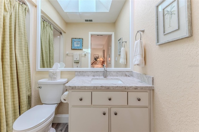 4460 Flounder Dr, Hernando Beach, FL 34607 - full bath featuring a skylight, vanity, a textured wall, curtained shower, and wood finished floors