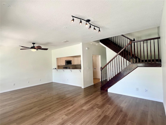 930 Woodbridge Ct, Safety Harbor, FL 34695 - unfurnished living room with a textured ceiling, stairs, ceiling fan, baseboards, and track lighting