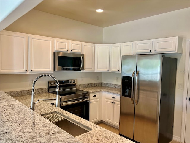 930 Woodbridge Ct, Safety Harbor, FL 34695 - kitchen featuring stainless steel appliances, light stone counters, white cabinets, recessed lighting, and a sink