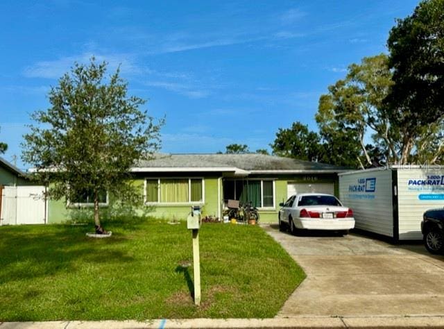 2016 Woodward Ave, Dunedin, FL 34698 - ranch-style house featuring a front yard and concrete driveway