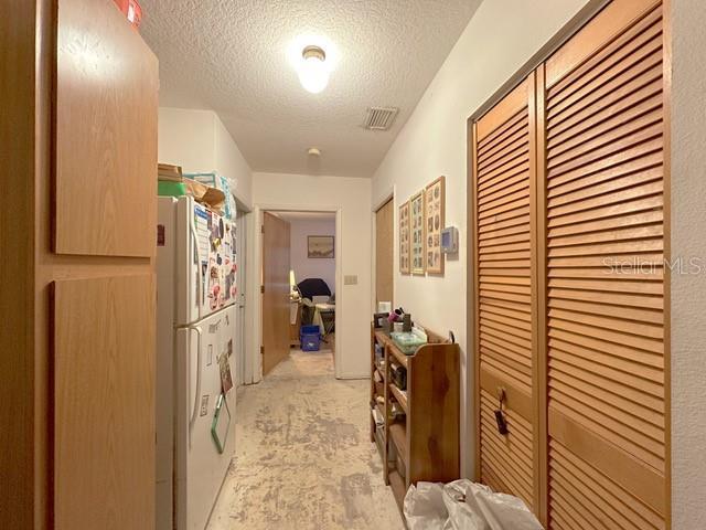 2016 Woodward Ave, Dunedin, FL 34698 - corridor with a textured ceiling and light carpet