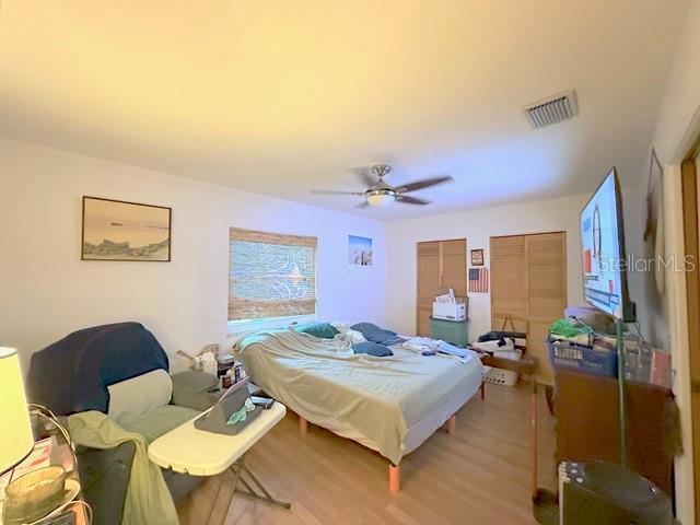 2016 Woodward Ave, Dunedin, FL 34698 - bedroom with light wood finished floors, multiple closets, and a ceiling fan