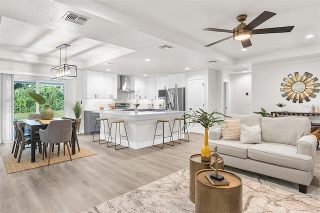 12064 Cradock St, Spring Hill, FL 34608 - living room featuring a tray ceiling, light wood-style floors, recessed lighting, and ceiling fan