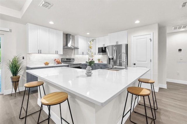 12064 Cradock St, Spring Hill, FL 34608 - kitchen with wall chimney range hood, appliances with stainless steel finishes, baseboards, light wood-type flooring, and recessed lighting