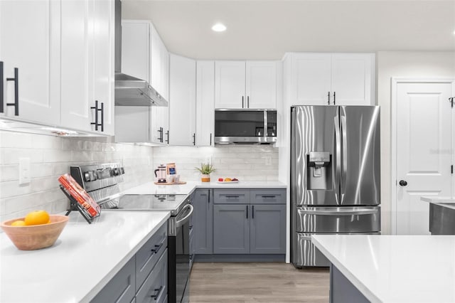 12064 Cradock St, Spring Hill, FL 34608 - kitchen with stainless steel appliances, wall chimney range hood, light countertops, white cabinetry, and recessed lighting