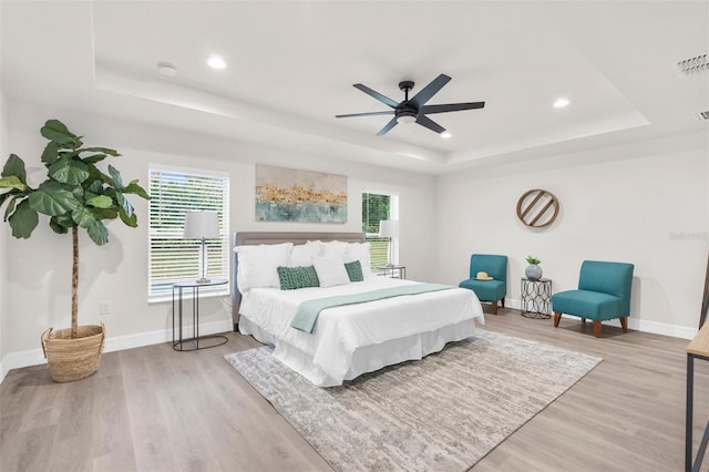 12064 Cradock St, Spring Hill, FL 34608 - bedroom with a tray ceiling, light wood-type flooring, baseboards, multiple windows, and recessed lighting