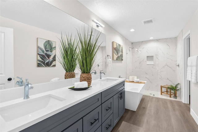 12064 Cradock St, Spring Hill, FL 34608 - bathroom with double vanity, wood finished floors, a freestanding tub, a marble finish shower, and recessed lighting