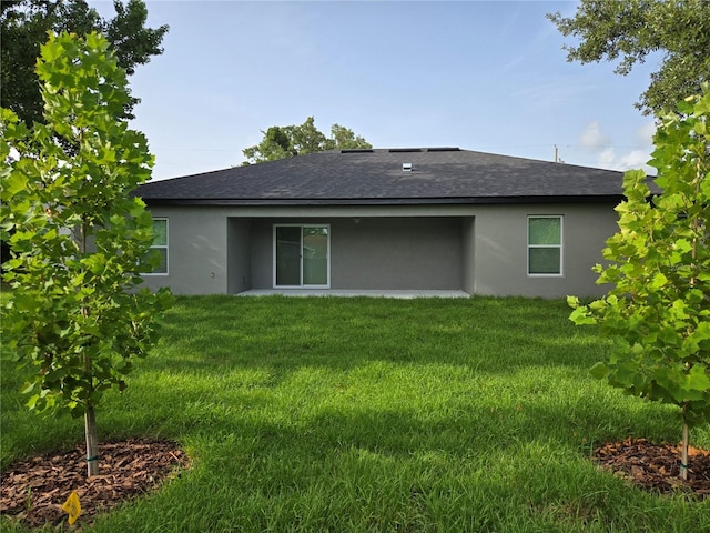 12064 Cradock St, Spring Hill, FL 34608 - back of house with stucco siding, roof with shingles, and a lawn