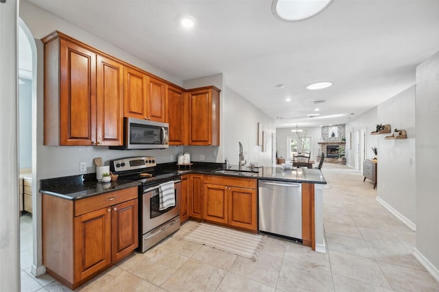 1623 Crossvine Ct, New Port Richey, FL 34655 - kitchen featuring appliances with stainless steel finishes, a sink, brown cabinetry, a peninsula, and open floor plan