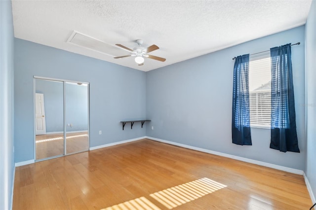 1623 Crossvine Ct, New Port Richey, FL 34655 - unfurnished bedroom featuring wood finished floors, a textured ceiling, a closet, attic access, and baseboards