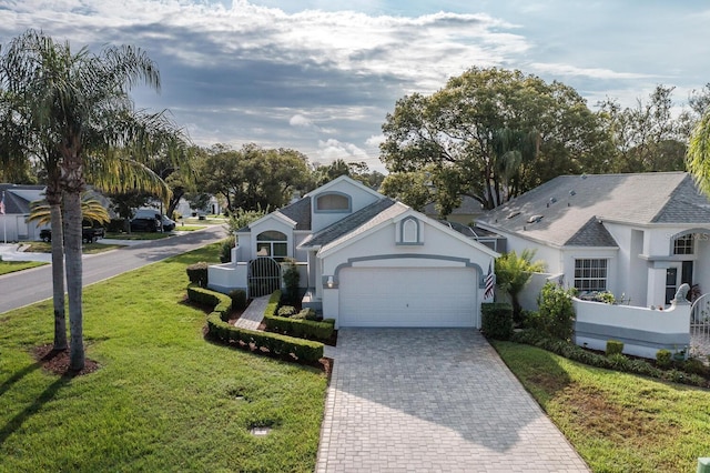 1084 Vista Fina Ct, Spring Hill, FL 34608 - view of front of house with an attached garage, decorative driveway, stucco siding, a front lawn, and a shingled roof