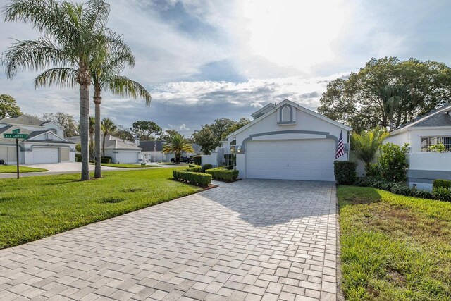 1084 Vista Fina Ct, Spring Hill, FL 34608 - view of front of house featuring decorative driveway, a front lawn, an attached garage, stucco siding, and a residential view