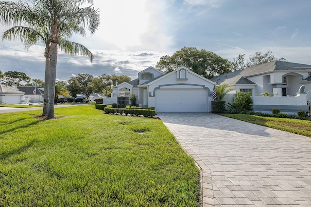 1084 Vista Fina Ct, Spring Hill, FL 34608 - view of front of house featuring decorative driveway, a front yard, an attached garage, and stucco siding