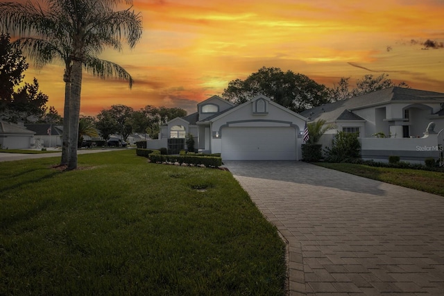1084 Vista Fina Ct, Spring Hill, FL 34608 - view of front of property with a lawn, decorative driveway, a garage, and stucco siding