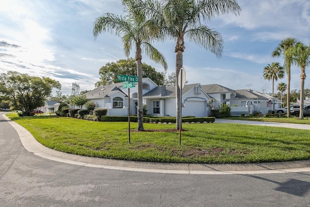 1084 Vista Fina Ct, Spring Hill, FL 34608 - view of front of property with driveway, a front yard, an attached garage, stucco siding, and a residential view
