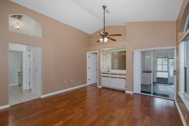 1084 Vista Fina Ct, Spring Hill, FL 34608 - unfurnished living room featuring ceiling fan, wood finished floors, high vaulted ceiling, baseboards, and a sink