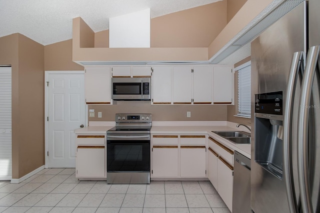 1084 Vista Fina Ct, Spring Hill, FL 34608 - kitchen with stainless steel appliances, a sink, light countertops, white cabinets, and light tile patterned flooring