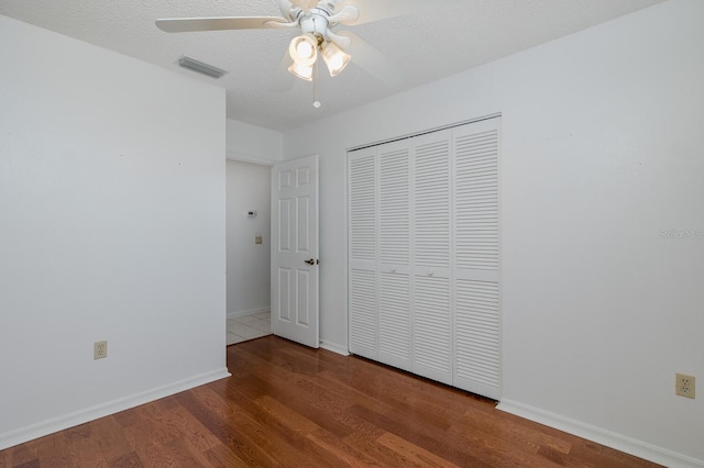 1084 Vista Fina Ct, Spring Hill, FL 34608 - unfurnished bedroom featuring wood finished floors, a closet, baseboards, and ceiling fan