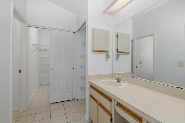 1084 Vista Fina Ct, Spring Hill, FL 34608 - bathroom featuring vanity, tile patterned floors, a spacious closet, and baseboards