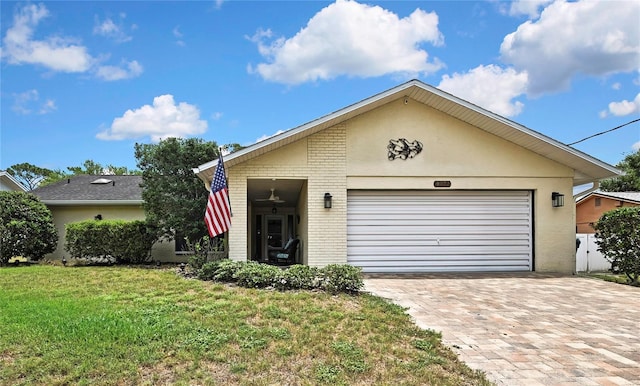4072 Everett Ave, Spring Hill, FL 34609 - view of front of property with brick siding, a front lawn, a garage, driveway, and stucco siding