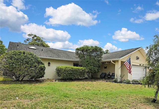4072 Everett Ave, Spring Hill, FL 34609 - rear view of property featuring an attached garage, a yard, and stucco siding
