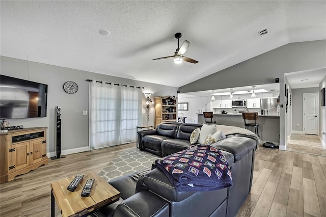 4072 Everett Ave, Spring Hill, FL 34609 - living room featuring a ceiling fan, lofted ceiling, a textured ceiling, light wood-style floors, and baseboards