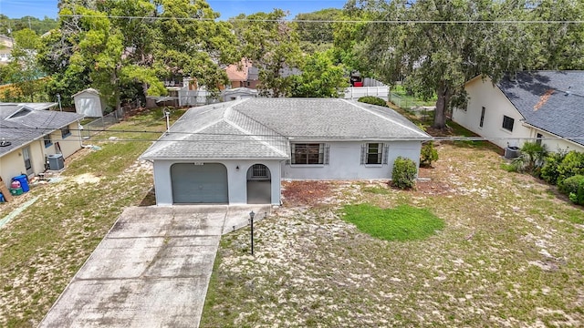 10139 Carrin Rd, Spring Hill, FL 34608 - view of front of house with stucco siding, an attached garage, concrete driveway, a shingled roof, and central AC unit