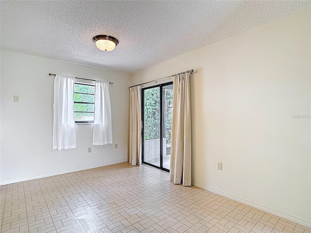 10139 Carrin Rd, Spring Hill, FL 34608 - spare room with brick patterned floors, baseboards, and a textured ceiling