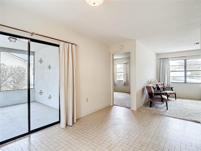 10139 Carrin Rd, Spring Hill, FL 34608 - spare room featuring brick patterned floors, healthy amount of natural light, baseboards, and a textured ceiling